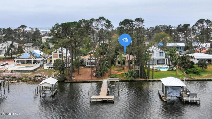 Waterfront home located on Grand Lagoon under $500k! This home is located on a lot that is over 200 feet deep.  You'll be able to park your full size RV under the covered parking with 30 amp electric hookup with room for your other vehicles. The dock extends into the lagoon where it has an boat lift.  The outside of the home has two storage rooms for your kayaks, tools, surf boards, etc. This home is located 6 blocks to the beach and 1.2 miles to St. Andrews State Park. Hot water Heater was replaced in 2018. Roof is 4 years old.