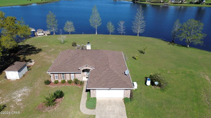 CURRENTLY UNDER CONTRACT, SELLER WILL CONSIDER BACKUP OFFERS. This is a unique storybook setting on a private 2.1 acre peninsula on Russ Lake, a cypress pond lined driveway, a charming well-maintained 2 bedroom brick home, and a boat house, gazebo, and fishing dock. Enjoy watching the sunset over the lake from your screened porch, or warm up by the wood burning fireplace on cool evenings. The split floor plan has bedrooms on either side of the living area, and the oversized 2-car garage includes a workshop! Lake views from the main bedroom, living room, kitchen, and dining room! Added features include a 2017 roof, water softener, termite bond, RING doorbell, motion lights, and whole house generator. Russ Lake Estates HOA fee is just $150/year. This idyllic home has it all... it just needs you!