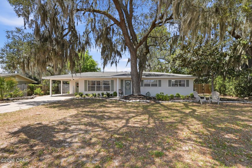 Now, this is FLORIDA living at it's best! Quaint Florida cottage in the heart of Lynn Haven surrounded by live oaks and Spanish moss, magnolias and palm trees that canopy the home.. This charming Southern cottage is light and airy and has been completely updated. Grab your golf cart and cruise to the bay or to one of the local parks. This is a 3 bedroom 2 full bath home that is perfect for the first time home owner or a family looking to downsize. The home has new ceramic tile flooring, a remodeled kitchen and lots of other amazing updates. The family room is cozy and spacious. The eat in kitchen has a wood burning fireplace.  The home features a large laundry room right off the kitchen and carport making it easy for groceries and additional storage. The bedrooms are big and offer lots of natural light. This charming home has a 
100 x 150 oversized lot with plenty of room for outdoor entertaining and tons of privacy. The entire backyard is fenced-in with large gates on both sides. There is a fire pit in the back that coveys with the home. The HVAC was replaced in 2023 and the roof was replaced in 2019. THIS HOME IS NOT in a FLOOD ZONE and there is NO HOA. One of the best features is the LOCATION. You are minutes to some of the top schools in Bay County and minutes to all of the best grocery stores, and restaurants. Lynn Haven is one of the most popular communities with plenty of parks, a public boat ramp, FREE concerts and so much more. The central location of the home makes it easy and fast to get to the beautiful beach, the airport, Tyndall Air Force Base and the Navy Base. Make an appointment to see this cozy cottage TODAY and you will feel AT HOME from the minute you walk in the front door!