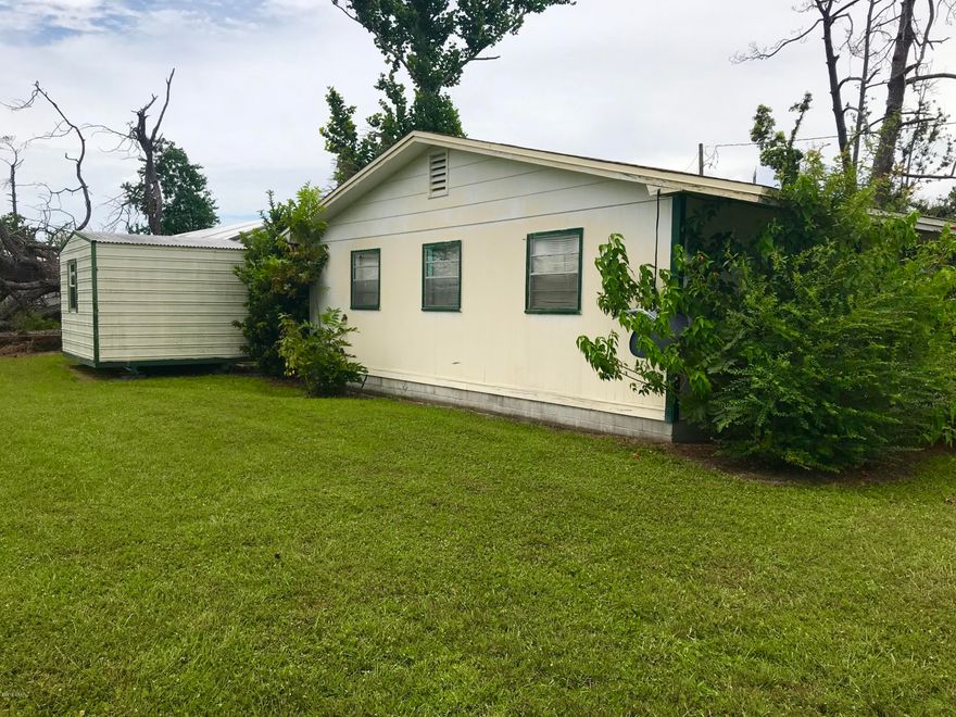 Corner lot! This home received damage from the hurricane. New energy star water heater. Newer AC unit, still in fine working order. The roof, which is less than 10 years old, is missing some shingles and a ridge vent, but has been well tarped to mitigate any further damage to the interior of the home. The main damage is to a lean-to porch addition, which can easily be removed. The home itself is in in solid condition, and was not hit by any falling trees. The owners are still in the process of having the home cleared out. The flooring has been stripped back. There is still lots to be done, but with a little work this would make a great home once again! Fallen trees have been removed from the property, and the grass and many mature flowering plants remain.