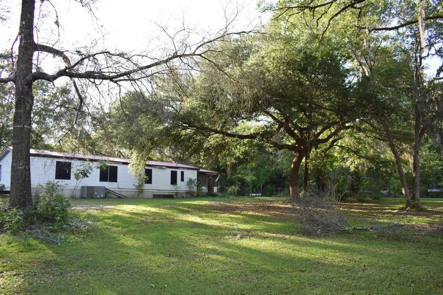 Looking for the perfect retirement property?  Cozy mobile home is in a quiet area on over 3.5 acres and... it is completely fenced!!! This property has a pond with a dock and is stocked with channel catfish and bream. There are 5 major lakes surrounding the property within 5 minutes driving distance, and deep sea fishing is only an hour away. The property is surrounded by hundreds of acres of Type 2 Wildlife Management land. Beautiful large mossy oaks and multiple fruit trees embellish this amazing property. There is a large pole barn, a covered parking shed and other outbuildings included.  Whether you want your own private retreat or if you want to make a great investment, don't let this opportunity pass you by!