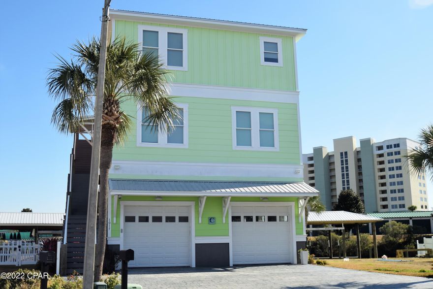 Don't miss this beautiful, well-maintained Waterfront home that offers a high level of luxury. This 3-story home is located in a gated community and has been designed to offer both comfort and elegance with spectacular top-of-the-line finishes throughout. When you take the three-stop elevator to the top floor of this dream home you will find an open living/dining room that's loaded with natural light and views of the bay. Along with vaulted wood ceilings, a chef's dream kitchen boasting custom cabinetry, stainless steel state-of-the-art appliances, gas range with griddle, quartz countertops, walk-in pantry, and an island with breakfast bar. The third floor also has a large 10ft by 30ft open porch and a spectacular Master Bedroom with an en suite bath featuring double sinks and a custom tiled shower. The second floor has high ceilings and offers three bedrooms, a laundry room a second living room and a 12ft by 30ft open porch, The Heated and Cooled garage is another bonus, and is not added to the homes heated and cooled footage, is set up for entertainment and still has enough room to park your cars. On the 12ft by 30ft back porch overlooking the water you will find an outdoor kitchen and a large open deck area. There is a covered boathouse with a lift that will accommodate up to a 32-foot boat and you are only about 10 minutes by boat to Panama City Pass which leads into the Gulf of Mexico. This smart home also has a camera surveillance system and a Ring doorbell.