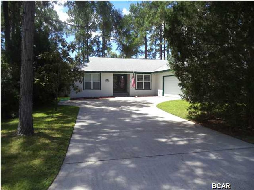 Location, privacy, canal, beautiful condition, this home is situated on an upscale Cul-de-sac in North Harbour. In the back, enjoy the beautiful pool and the privacy afforded by the eight foot fence and wooded band along the canal. In the front, you have a large driveway and the privacy provided by the large cedar trees lining the road. This white stucco house has a neighbor on one side and an empty wooded lot on the other. Utilities include gas and electric, Lynn Haven water and sewer. Tile is laid throughout the home with various complementing colors, sizes, and orientations applied. Looking through the custom etched front French doors you'll have an unobstructed view to the backyard swimming pool. This home's open floor plan has a foyer and dining room, separated by a single wall,