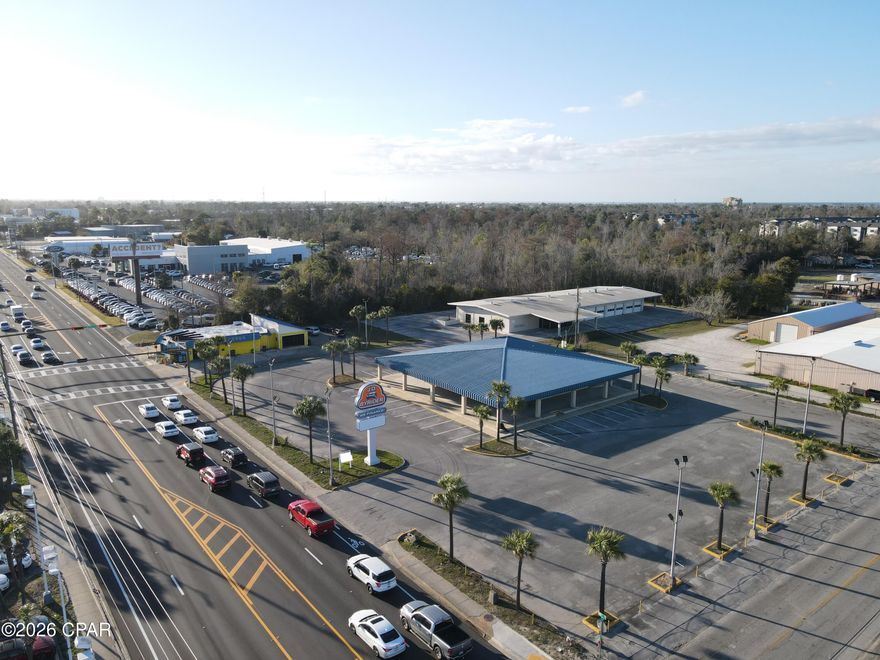 Positioned along one of Panama City's most recognized commercial corridors, 704 W 15th Street represents a rare opportunity to acquire a substantial, fully improved automotive commercial property in the heart of Bay County's established dealership row.
The offering consists of two contiguous parcels totaling approximately 8.09 acres. The improved parcel encompasses 2.53 acres and is developed with a professional office/showroom building and a fully equipped automotive service garage, providing immediate operational capability for a dealership, fleet operator, or service-oriented automotive business. The second parcel comprising 5.56 acres offers significant expansion potential, additional inventory staging, overflow parking, or future development -- a premium commodity in this high-demand corridor.
The property sits at a prominent corner location with access from both Highway 98 (15th Street) and Florida Avenue Showcase, providing exceptional visibility and ingress/egress for high customer traffic volumes. It is centrally located amongst the other new car dealers in the county Showcase, making it an ideal home for a new or used car dealership, watercraft dealer, or any automotive-related enterprise seeking to benefit from co-tenancy with established franchise dealers.
Property Highlights:

Total site: ±8.09 acres across two parcels (2.53 AC improved | 5.56 AC additional)
Improved parcel features office/showroom and automotive garage
Corner location -- dual access from Hwy 98 (15th St) & Florida Avenue
Situated within Panama City's primary automotive retail corridor
Excellent visibility and high traffic counts on a major arterial highway
Suited for auto dealership, powersports, watercraft, fleet, or service operations

This Triple Net lease property offers the scale, infrastructure, and strategic location rarely available in Panama City's competitive automotive market. Whether for owner/operator use, investment, or redevelopment, 704 W 15th Street delivers a compelling combination of improved facilities and raw land in one of Bay County's most active commercial destinations.