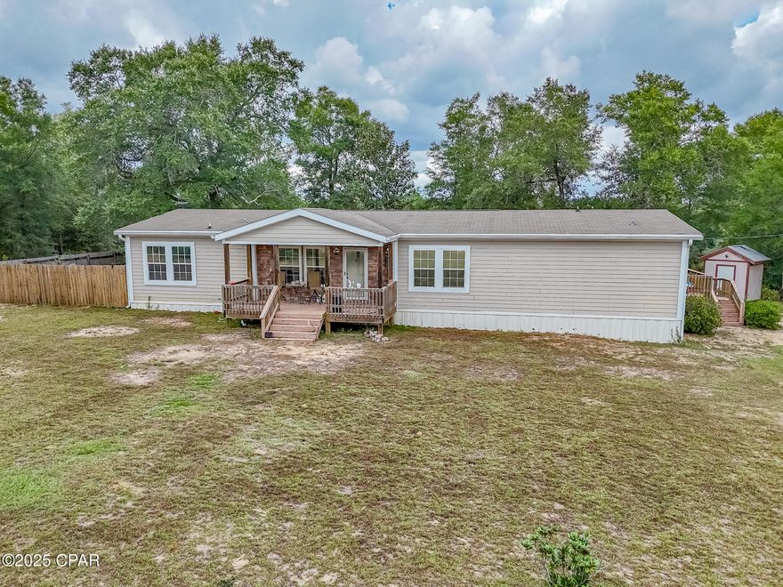 Ask about FREE appraisal and NO lender fees (Total savings $1495)! COUNTRY LIVING ON 10 ACRES—SPACE, PRIVACY, AND ROOM FOR EVERYTHING YOU LOVE. Set on an approximately 330' x 1,350' tract in North Bay County, this 2011 double-wide offers 2,160 sq ft with 3 bedrooms and 2 baths, an easy-to-live-in layout, and multiple outdoor living spaces. Inside, a generous great room centers around a cozy fireplace, the kitchen features a breakfast bar with all major appliances included (range, refrigerator, dishwasher, microwave), and the dining area flows right out to the porches for effortless everyday living.

Bring the animals, gear, and big toys—Agricultural zoning with horses allowed, a useful pole barn, and abundant parking for boats, RVs, trailers, and more (detached carport, oversized driveway, unpaved access) make this property truly versatile. Enjoy morning coffee on the screened porch, grill on the open deck, or unwind on the covered front porch while taking in the wooded backdrop. Practical features include private well and septic, central electric HVAC with ceiling fans, vinyl siding, asphalt roof, smoke detectors, and an intercom system. No HOA, and a peaceful dirt/clay road approach adds to the quiet, rural feel.

If you've been searching for a comfortable home base with real elbow room—and the freedom to garden, keep animals, store equipment, or simply spread out—this one delivers.