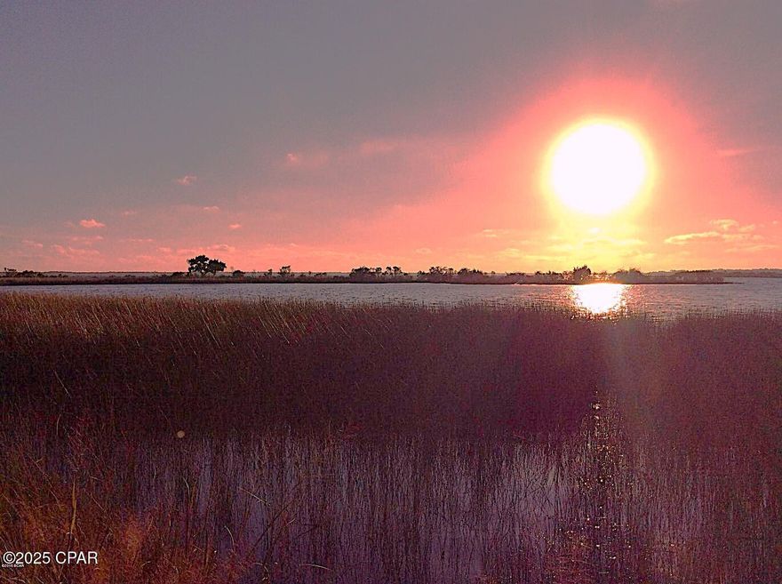 Secure Gated Coastal Community. Breathtaking views of St. Andrews Bay. Nearly 1/2 Acre WATERFRONT! Spectacular sunsets from the back yard. This sought after community features underground public utilities, natural landscaping, tennis courts privacy, a community boat launch, and lots of fishing! Close to Tyndall AFB and the sugary sand beaches and many social attractions of the Panama City Beach / Emerald Coast area., Tyndall Air Force Base, only 9 minutes from S Tyndall (shopping street). Low HOA fees.  Build your dream home here! See HOA Covenants for architectural building guidelines. Lot dimensions are taken from the recorded plat and are approximate.