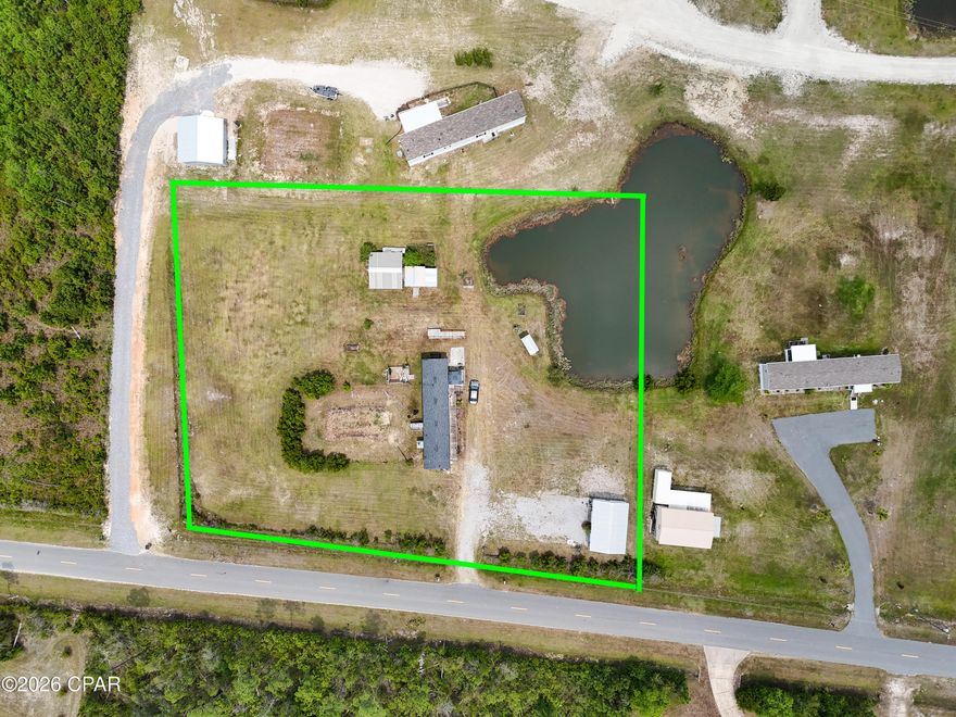 Tucked away on 1.82 acres, this beautifully maintained 2-bedroom, 2-bath home offers the perfect balance of comfort, functionality, and peaceful country charm--just minutes from the stunning beaches of Mexico Beach. Inside, you'll find a bright, inviting layout with durable wood-look flooring throughout and a spacious kitchen designed for both everyday living and entertaining. The large island with seating creates a natural gathering space, while the split floor plan provides privacy, with a generous primary suite featuring a walk-in closet plus additional storage. Step outside, and the property truly shines. A tranquil pond sets the tone for relaxed outdoor living, creating a serene backdrop to enjoy from the deck. The land is thoughtfully improved with features that make it both practical and versatile, including a double detached garage, a 14x20 pole barn, and a 12x12 storage building complete with an attached chicken coop and fenced area--perfect for those looking to embrace a hobby farm lifestyle or simply enjoy extra space. Additional highlights include handicap-accessible features, an RV hookup for added convenience, and a deck already equipped with power for a future hot tub--making it easy to create your own private retreat. Garden enthusiasts will appreciate the raised planter beds and unique sunflower garden, adding charm and character throughout the property. With ample road frontage and plenty of open space, there is also potential for future division or expansion, offering flexibility for a variety of uses. Whether you're looking for a quiet homestead, a weekend escape, or an investment opportunity near the coast, this property delivers a rare combination of space, improvements, and location.