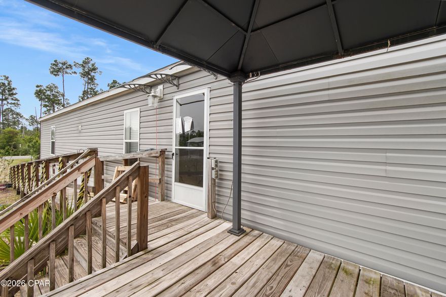 Tucked away on 1.82 acres, this beautifully maintained 2-bedroom, 2-bath home offers the perfect balance of comfort, functionality, and peaceful country charm--just minutes from the stunning beaches of Mexico Beach. Inside, you'll find a bright, inviting layout with durable wood-look flooring throughout and a spacious kitchen designed for both everyday living and entertaining. The large island with seating creates a natural gathering space, while the split floor plan provides privacy, with a generous primary suite featuring a walk-in closet plus additional storage. Step outside, and the property truly shines. A tranquil pond sets the tone for relaxed outdoor living, creating a serene backdrop to enjoy from the deck. The land is thoughtfully improved with features that make it both practical and versatile, including a double detached garage, a 14x20 pole barn, and a 12x12 storage building complete with an attached chicken coop and fenced area--perfect for those looking to embrace a hobby farm lifestyle or simply enjoy extra space. Additional highlights include handicap-accessible features, an RV hookup for added convenience, and a deck already equipped with power for a future hot tub--making it easy to create your own private retreat. Garden enthusiasts will appreciate the raised planter beds and unique sunflower garden, adding charm and character throughout the property. With ample road frontage and plenty of open space, there is also potential for future division or expansion, offering flexibility for a variety of uses. Whether you're looking for a quiet homestead, a weekend escape, or an investment opportunity near the coast, this property delivers a rare combination of space, improvements, and location.