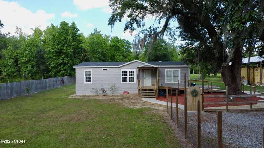 Charming 2021 Double-Wide on Spacious 0.59-Acre Lot - Fully Upgraded and Move-In Ready! 
Welcome to your perfect blend of comfort, space, and functionality! This beautifully maintained 2021 double-wide manufactured home sits on an expansive 0.59-acre lot, offering the best of peaceful country living with modern upgrades throughout.

Shaded by two majestic oak trees, the outdoor space is a true retreat. The property is fully fenced for privacy and security, with thoughtful landscaping and custom walkways that enhance its curb appeal and usability. Whether you're enjoying your morning coffee on the covered front porch or hosting a weekend BBQ, the outdoor setup is ideal for relaxing or entertaining.

This 3-bedroom, 2-bath home features an open-concept layout with modern finishes and plenty of natural light. The spacious primary suite includes a large soaking tub—your personal spa retreat—along with ample closet space. A dedicated laundry/utility room adds everyday convenience and extra storage. The kitchen features newer stainless steel appliances and both eat-in and bar space dining. Sliding doors lead to a wooden deck and expansive back yard, perfect for entertaining!

Property highlights include: 3 bedrooms, 2 full bathrooms with spacious layout; Large soaking tub in the primary suite for ultimate relaxation; Dedicated laundry/utility room with extra storage; Nest smart learning thermostat; Heat pump A/C with ceiling ducts and vents; Fully fenced 0.59-acre lot - private and secure; Newer pole barn with wired storage containers - ideal for a workshop or hobby space; Extensive land improvements: landscaping, custom decking, and walkways throughout; Two mature shady oaks providing charm and natural cooling; Plenty of room to expand, garden, or customize further to your liking.

Pole barn is 30'x48'x12' and workshops are made from two 8'x40'x9'6'' sealed, weatherproof, and lockable containers with 110v and 220v electricity for workshop, storage, and lighting. Driveway has been recently graveled and a 12' car gate allows for easy vehicle access to the completely fenced-in property. 

Just minutes from Marianna - close to shopping, dining, and schools

This property is a rare find with all the hard work already done - just move in and enjoy! Perfect for homeowners looking for space, functionality, and a touch of rural tranquility without sacrificing modern convenience.