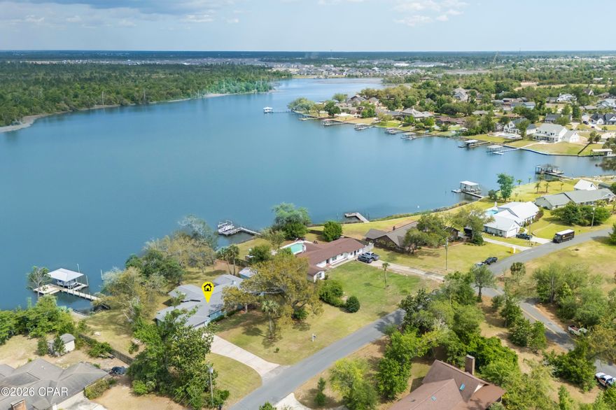 Waterfront Paradise in Lynn Haven - No HOA! This lovely home offers 3 bedrooms, 3 baths with a flex room that is perfectly situated on the water in the desirable College Point Subdivision. Enjoy direct access to the Gulf from Mill Bayou with your own private covered boat dock and lift, ideal for boating, fishing or simply soaking in some sun. Everyday there's an opportunity to watch nature in your own backyard, the best are the dolphins and the pelicans that make their rounds! This beautifully maintained property also features a large screened-in porch and an open deck that's perfect for year-round entertaining. The backyard paradise also offers a large storage shed for all your gear and is shaded by majestic canopy oaks that provide natural beauty and comfort. This home has a double car garage and has spacious parking with a side yard for an RV or a boat trailer. Inside, you'll find a spacious, open floor plan with water views from just about every room, ample natural light and a blend of comfort and style throughout. Having no HOA, gives you the freedom to truly make this home your own. Don't miss this rare opportunity to own a piece of waterfront paradise in one of Lynn Haven's most sought-after locations!