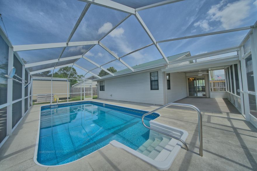 This updated 3 Bedroom pool home in popular Shadow Bay has an open floor plan and easy-care tile flooring throughout the main living areas. The kitchen features a breakfast bar, quartz counters, and oak cabinets. The adjoining dining area is open to the living room with cathedral ceilings and a wood burning fireplace as the rooms focal point.  All 3 bedrooms have new berber carper and the bathrooms have also been updated to include quartz counters, oak cabinets, and tiled shower/tub surrounds. A sliding door leads to a screened Florida room and out to the screened inground pool. The backyard is fully fenced and includes a workshop with electricity and a well for the irrigation system, and the house has gutters. There's also a 2-car garage with lots of built in storage. The metal roof was installed in 2017.Shadow Bay is a quiet neighborhood with sidewalks; just a few minutes from shopping, restaurants, Tyndall Air Force Base, and the ship yard. Age, Square Footage, lot and room sizes approximate, if important please verify.