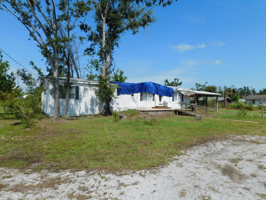 1/2 acre on Airport Rd.    Manufactured home is 1,782 SF 3 bedroom, 2 bath.  Home has  hurricane damage and is being sold AS/IS without repairs or other considerations.  Value appears to be mostly in the land. All sizes are approximate, so please measure if important. DO NOT ENTER PROPERTY WITHOUT INFORMING LISTING AGENT.