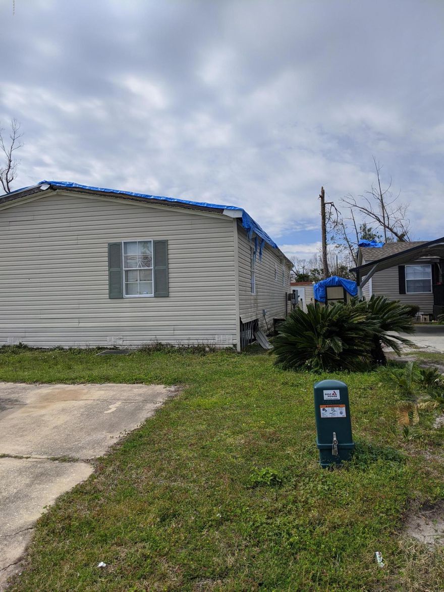 Investment opportunity. Storm damaged but dry, will need roof and quite a bit of rehab work inside. This very nice double wide home approximately 1860 s.f. Very close to Tyndall AFB, shopping, and schools.  Open living space,  built-in oak book shelves. Master bedroom has his & her closet. Master bath has separate shower and double vanity. Additional bedrooms have walk-in closets.  Oversize pantry and laundry room. *** All measurements are approximate, verify if important.***