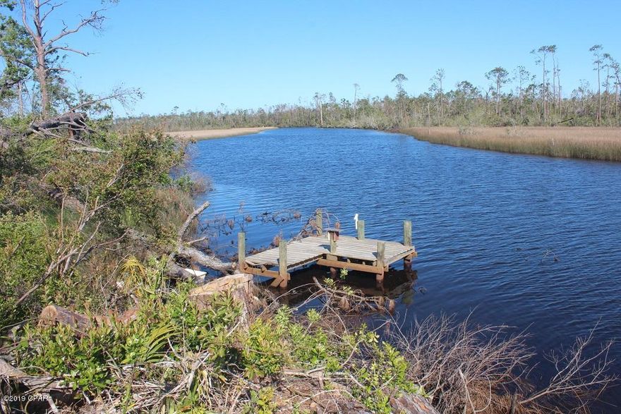 Beautiful 100x375+- waterfront lot on Cooks Bayou.  This amazing lot could be the next place you build your dream home.  The lot has been partially cleared and is located on Cooks Bayou.  Cooks Bayou is direct access to the Intracoastal Waterway and Gulf Of Mexico.  There is already a dock in place for your boat.  The property is high and dry and there is a small bluff at the water's edge.  This is truly a gorgeous piece of property.  The county is in process of raising the Hwy 2297 bridge to accommodate larger boats through Cooks Bayou.  The lot width will be 100' wide and the length is approximately 375' to the water, to be determined by Buyer's survey.  The sale does not include full lot per Baypa.net.  Don't miss out on your chance to own a piece of paradise. No mobile home allowed.