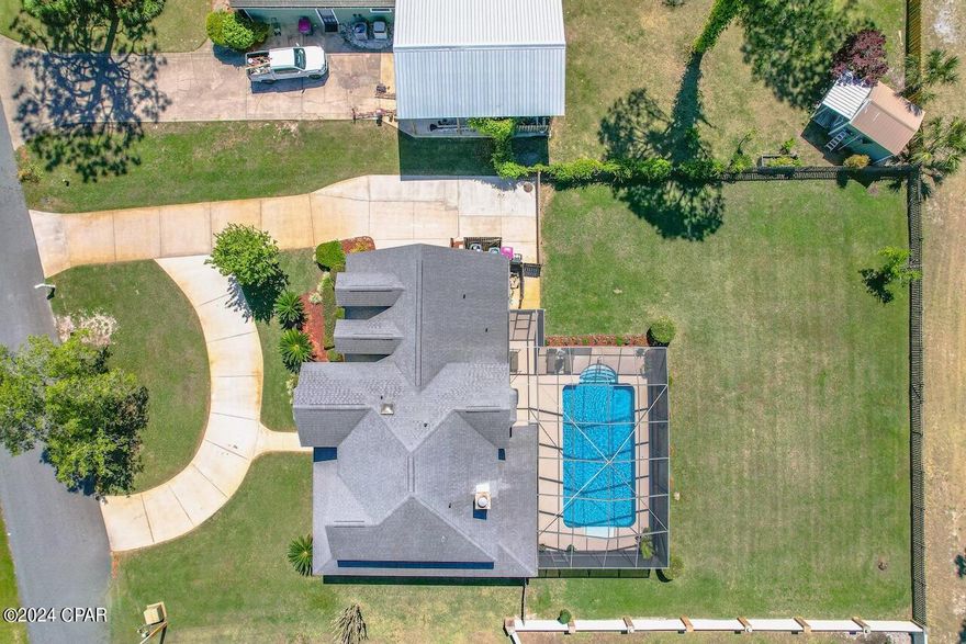 Introducing this exquisite custom-built, single-owner residence proudly situated at the Legacy Golf Course overlooking the 14th fairway. Boasting over 2600 sq ft of meticulously maintained living space, this home offers an abundance of natural light through its numerous windows, showcasing breathtaking views of the pool area and golf course. Featuring hardwood floors, 10-foot ceilings, dual HVAC units, a cozy fireplace, and a versatile office/5th bedroom on the main level. The kitchen is a chef's dream with quartz countertops, soft-close cabinets, and a breakfast bar, complemented by a bay window breakfast nook overlooking the expansive 16x32 ft pool. Upstairs, the master suite boasts a luxurious bathroom and spacious walk-in closet, while three additional generously sized bedrooms offer comfort and charm. Outside, the pool area features over 1000 sq ft of decking, a covered patio, and a screened enclosure, providing the perfect setting to unwind amidst the tranquility of the golf course surroundings. Ample parking includes an extra-large driveway, circular drive, and a double car garage with a built-in workshop area. Nestled within the unique Colony Club community, known for its proximity to Gayle's Trails, Pier Park, and easy beach access, this home offers an unparalleled lifestyle opportunity. Truly special, come experience it for yourself.