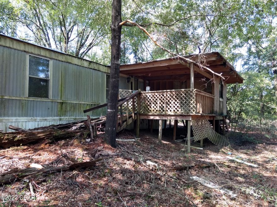 Nice secluded 2-acre parcel at the end of the road. Has a good deep well in working condition. Power pole already in place. Single wide mobile home that was damaged in a storm several years ago. Might be able to restore it. Condition of the septic tank is unknown. Lots of big shade trees.