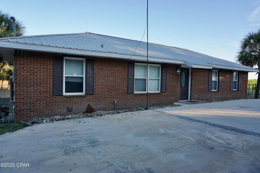 This unique home is nestled in a quiet area surrounded by beautiful pastureland.  The three-bedroom, two-bath home features a bonus room with french doors opening to an expansive backyard, perfect for a hobby room or extra bedroom.  There is a dedicated laundry room and tons of covered parking for boats, RVs, card, etc. Bring your toys because there's space for them all on the 1.21-acre parcel.  The property is completely fenced and conveniently located minutes to Marianna for nearby shopping and restaurants. Enjoy the quiet of country life while still living close to local schools and amenities. 

Note: Current seller is the personal representative of the estate and has not resided at the property. Previous listings of this property indicate that the property has flooded in the past. It is not currently in a flood zone and there is no known current flood damage to the property but potential buyers should investigate. All measurements are approximate and should be confirmed by buyer.