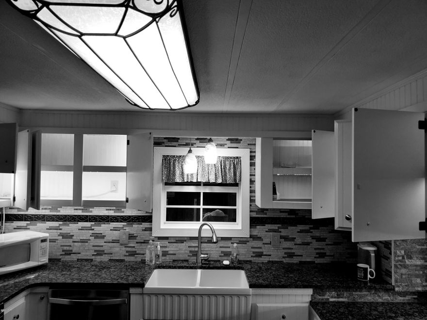 This move-in ready, 4 br, 2 ba manufactured home has been renovated and updated. Newly remodeled kitchen and bathrooms with granite counter tops - Italian farm sink and tiled back splash. This chain link fenced country home comes with 5 outbuildings, 7 outside faucets and drip irrigation on timers.   Large circled gravel drive installed by local professional. 800 square foot brick patio and 34 X 12 foot pergola with brick walkway to the front 2-car garages. The Master bathroom is equipped with a heated Whirlpool soaker tub with massage and 8 jetted rain shower panel, and of course a flat panel TV. .   Kitchen is updated with stainless steel appliances and dishwasher.  Renovated upper cabinets are lighted both inside and under cabinets.  Lower cabinets have stainless steel pullouts.