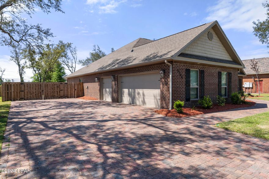 This 4bd, 2.5ba 2800+sqft(with a 3 car garage)brick home on a half acre lot in the gated and very desirable waterfront community of Bayou Oaks North will take your breath away. And the added benefit of no homeowners association...which means...NO HOA FEES!! Additional RV parking with power as well. Roof was replaced after Hurricane Michael(2018). Walk in to a formal dining room on the left and an office/bedroom on the right. The double tray ceilings are gorgeous and give the home incredible height. The custom kitchen comes with granite countertops, built in microwave/induction oven combination, a pot filler and stainless steel appliances, french door refrigerator, induction flat range top, island with a built in wine rack, large pantry, stone backsplash, recessed lighting, and a chandelier pendant over the bar island. The large living room features a stone electric fireplace, double tray ceilings, and gorgeous hardwood floors. Enter the master bedroom(with tray ceilings) to an unparalleled master bathroom with a rain head shower, an additional shower head...and a shower seat! The large laundry room has a utility sink and the sellers just purchased a smart Samsung washer and dryer that can be controlled from your phone. Interior has been partially repainted. Step outside to a covered outdoor porch with a cooking area and built in smoker/barbecue. The completely fenced in back yard guarantees maximum privacy and is SCREAMING for a pool...and we are already providing the outdoor shower :-) The neighborhood fishing dock is steps away and  there is a public boat ramp right outside of the community(to the right). Hurry before this beauty gets away! All information is approximate and should be verified by buyers if important.