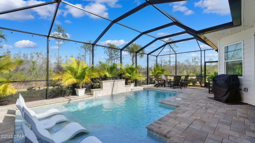 This stunning Breeze Bay w/pool overlooking a preserve with neighboring pond views is a MUST SEE in the resort-style living community of Latitude Margaritaville Watersound, a 55+ & Better community nestled along the Intracoastal Waterway and just 7 miles from the sugary white sands of the Gulf of Mexico. Step inside this beautifully furnished, open-concept living home and discover sophistication, warmth and style throughout offering coastal living for inside and outside enjoyment. After noticing the beautiful custom coffered ceilings w/tongue & groove and custom chandeliers as you enter, you will see the expansive glass slider doors leading to your outdoor oasis featuring a custom heated saltwater pool with three waterfall spillers, tanning ledge, Edison lighting, Cooleroo sunshade, custom pavers, and an impressive Minka fan—all perfect for entertaining, relaxing or enjoying morning coffee or an afternoon cocktail with the soothing sound of cascading water. The gourmet kitchen overlooking the main living area is a showstopper with 42'' upgraded upper cabinets with crown molding and under-cabinet lighting, Level 4 quartz countertops and backsplash, pots-and-pans drawers, pullout organizers, garbage disposal button on the oversized island, custom hardware, and premium KitchenAid appliances—including a convection/steamer/broiler microwave and a five-burner gas cooktop. A stainless steel counter-depth Frigidaire refrigerator and wine cooler both remain. The dining room features a tongue-and-groove accent wall, extra can lights, and a chic chandelier. The oversized living room boasts custom beams with tongue-and-groove inlay, designer draperies, floor outlet, a hi-jack for wireless TV mounting, and a striking Monte Carlo ceiling fan. The primary suite is a serene retreat with custom draperies and blackout shades, tray ceiling, closet organizers in his & her closets, dual vanities, custom cabinetry with pull out shelving, Level 5 quartz counters, Level 5 tile, zero-entry shower and an upgraded soaking tub. Both spacious secondary bedrooms include upgraded fans, blackout shades, and custom sheers, with wood shelving and custom storage solutions carried throughout their closets and adjoining baths. All guest baths include upgraded cabinetry, dovetail drawers, custom hardware, quartz counters, and Level 5 tile all the way up shower walls. The laundry room offers upper cabinetry, custom knobs, sink, Level 4 quartz, and a built-in ironing board. Latitude Margaritaville Watersound offers a plethora of amenities: Town Square boasts a Bandshell, Barkaritaville Dog Park, Bar & Chill 2 story restaurant offering views of the Intracoastal Waterway, resort-style community pool, tennis and pickle ball courts, fitness center with/indoor lap pool, music Fri. & Sat. nights, kayak launch, game lawn area with corn hole, ping pong, putting area, pool table, bocce ball, pet grooming shop, theater, workshop, pottery shop and numerous walking/golf cart trails. Publix is coming. Future development is underway on a public marina and commercial area for restaurants, shopping and entertainment. Additional features include: Garage with dedicated 20-amp refrigerator outlet, extra outlets for golf cart charging, storage cabinets, epoxy floor, 2 fans, decked attic storage; extra storage in HVAC room; Smart-enabled garage opener w/camera. This smart home is impeccably maintained and packed with upgrades—including custom paint, crown molding, oil-rubbed bronze hardware, 8' doors and commercial-grade 20-mil LVP flooring. A long list of enhanced lighting features includes added can lights in multiple rooms, 23 dimmer switches, additional outlets throughout the home and lanai, and exterior floodlights. Wi-Fi-enabled systems allow you to control the pool, thermostat, front door, and garage from your phone, while the whole-house Air Essentials scent system (Miami scent) adds a luxurious finishing touch. With over $180,000 in upgrades, this home is truly move-in re