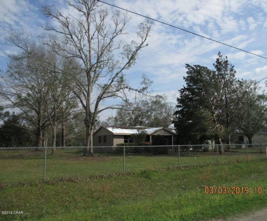 Brick Home on 1.16 Acre. 3BR/2B with 1,296 SF plus a 2 car detached garage and large screen porches. Located in Wewahitchka. Living room with fireplace. Split bedroom floor plan. Fenced front yard. Being Sold ''AS IS''. Well and Septic.