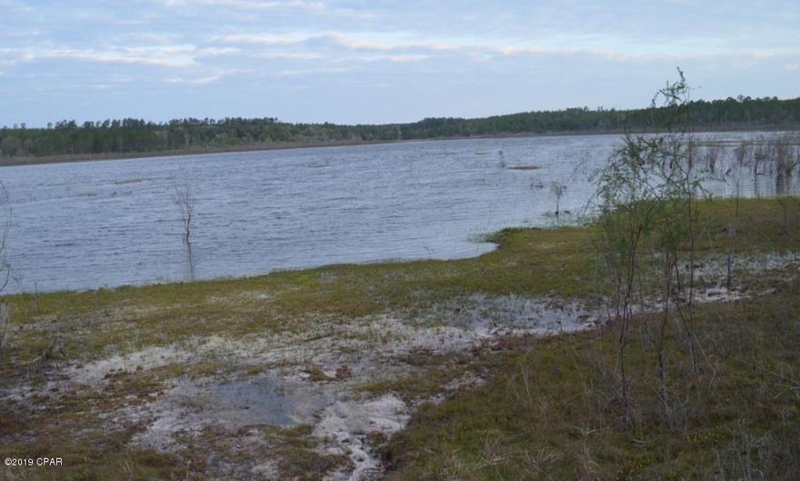 Gentle sloping lot on a paved road within less than 3 miles north of the intersection of wy 77 and State Rd 20.   Sand pond is located in the hills just perfect location within equidistance  between Chipley and Lynn Haven.  The 4 laning to Lynn Haven starts at Hwy 20 and currently slated to go north to I 10 interstate.  This property will allow horses, mobile homes less than 5 yrs. old, single family residences at least 100 sq. ft. excluding porches, garages and carports.  No dog kennels allowed. Docks may extend into the lake no farther than 30 ft. from shore. Jet skiis allowed Weekends and holidays.