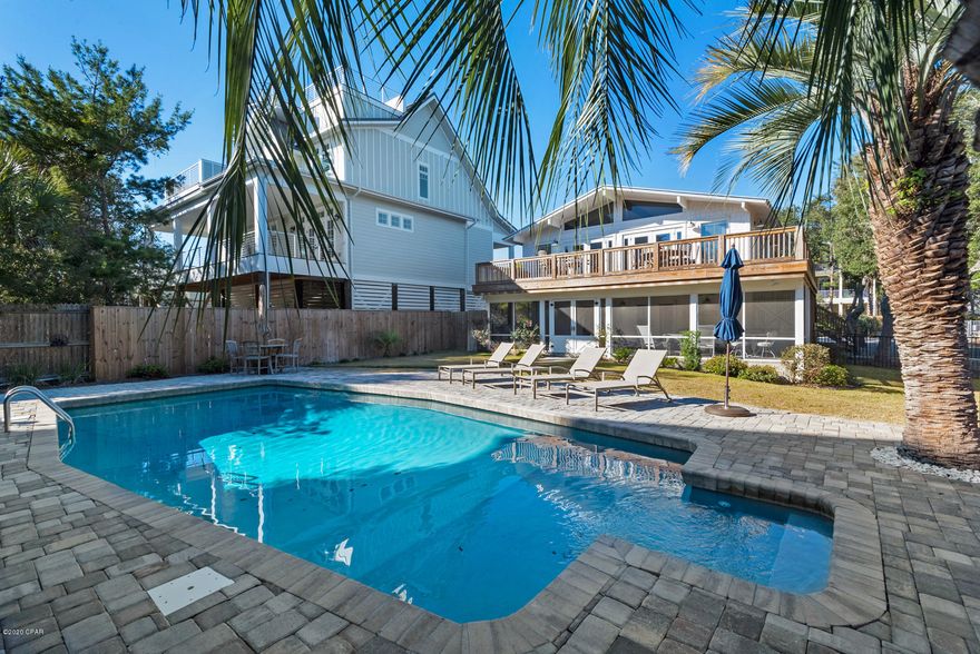 The Perfect Beach home! Nestled among lush landscaped surroundings, you will find a peaceful sense of tranquility and seclusion awaiting you, and all within 900' of the beach! No expense was spared with the high-end construction of this totally renovated property. Professionally designed and decorated, this well appointed home exudes charm and functionality with the utmost attention to detail. Enter the heart of the home where you will be drawn to the welcoming warmth of the vaulted beamed ceilings and expansive glass. The spacious living area with washed brick fireplace and light filled chef's kitchen, opens to a large deck overlooking the back yard and pool. A glimpse of Draper Lake can be seen in the distance. More... On the upper level you will also find two bedrooms each with vaulted beamed ceilings, and a hall bath. The lower level features 3 bedrooms each with their own bathroom, and another large living area with fireplace and refreshment bar. Grab something cool to drink and step out onto the amazing screened porch expanding the entire length of the house. Catch an ocean breeze and energize yourself for the beach while relaxing in the back porch swing or around the extra large pool surrounded by lush palm trees. This home sleeps 12 people providing plenty of room for family and guest and offers convenient parking space for all. Perfect for a primary home, vacation home or if you are looking for a rental investment, you have found a winner! With a strong history and rentals on the books, you are "Rental Ready" to go!