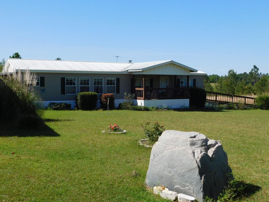 Quiet Country Living- Spacious DWMH on 10.01 acres in Twin Lakes Subdivision. Kitchen offers a breakfast nook, island with sink and dishwasher, gas stove. Living/Dining combo with wood burning fireplace. Master has huge walk in closet, Master bath has walk in tub, separate shower. 2 additional bedrooms with walk in closets and full hall bath tub and shower. Enclosed back porch with hot tub. Covered front porch. Attached carport. Newer metal roof. 38x40 workshop with electricity. Landscaped yard, wooded towards back of property.