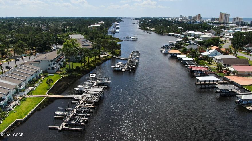 NORTH LAGOON WATERFRONT COMPLEX - END UNIT TOWNHOUSE - LOCATED BY THE POOL - BOAT SLIP INCLUDED! Looking for a vacation home or permanent residence?  This property is easy maintenance and adds to your beach lifestyle! Enjoy the pool or take a ride on your boat down North Lagoon out to Shell Island or into the gulf!  The interior of the townhouse features 2 bedrooms (one with a balcony) and 1 bathroom upstairs, a 1/2 bath downstairs (very convenient) and an open living/dining concept which adjoins the kitchen. There is also an interior laundry room. Compared to many, the HOA is very affordable - only $250/month. No short term rentals. Call today for a private preview.