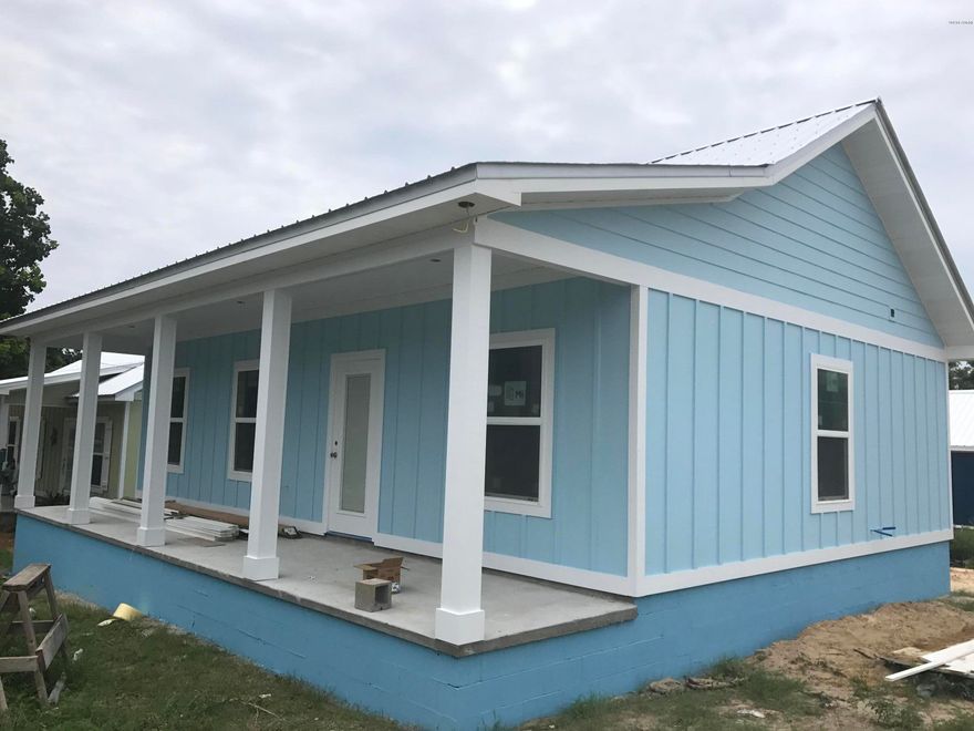 Final state of construction.   LARGER FLOOR PLAN THEN OTHERS SOLD IN COMMUNITY. 840 SF with 210 sq ft front porch.   Home is 2x6 Wood Frame Construction. Hardie Board & Batten Siding. Metal Roof. Hurricane Rated Impact Windows.  Vaulted Ceilings in Living Room and Kitchen, Wood Floors Throughout. Tile Floors in Bathrooms. White Vanities in Bathrooms. One Fiberglass Shower and One Fiberglass Tub with Shower Surround. White Shaker Style Cabinets with Simple Cottage Hardware in Kitchen. Granite Countertops in Kitchen. Stainless Steel Appliances. Smooth Top Self-Cleaning Range. Over Range Microwave Hood. 18-20 Cu Ft Refrigerator with Ice Maker in Freezer. Garbage Disposal. 3 Ceiling Fans. Approx. 10' x 20' Concrete Driveway. Concrete Sidewalk from Driveway to Front Porch. Additional Gravel Parking on the Side. Fixed Decorative Wood Shutters - Wood. . One front Door Light & One Back Door Light. Interior & Exterior Paint Colors - Buyer's Choice if you buy now.