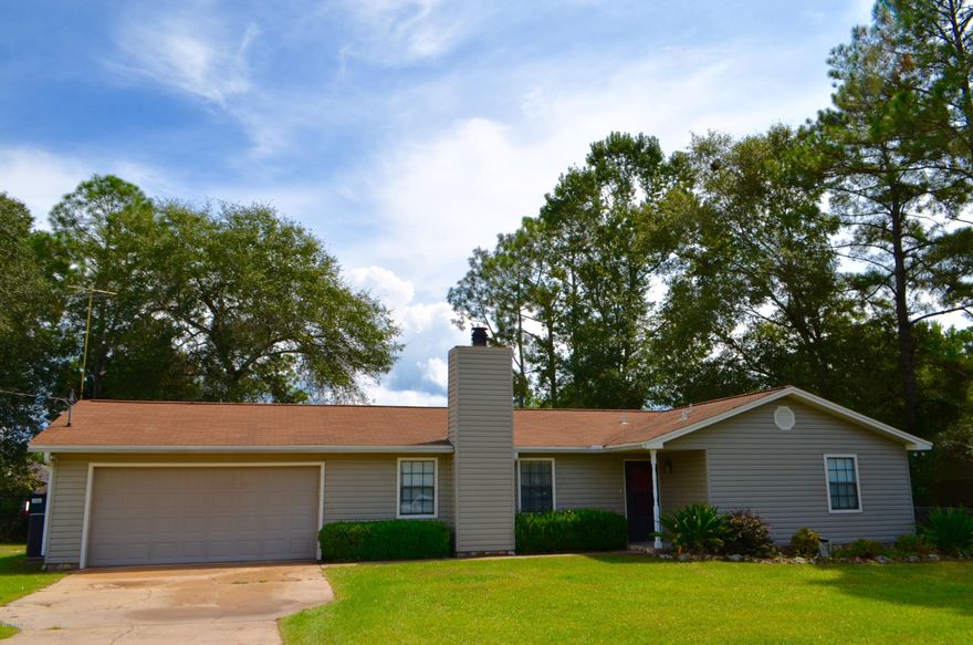 You can't beat this price for country living and still be near all the amenities of Panama City. Open kitchen/dining area leads to a covered patio through the French doors. The inviting living area has a wood-burning fireplace along with a custom made mahogany built-in shelving unit. Large lot with beautiful fenced back yard including your own pirate's tree house and children's swing set!! Tile floor, vinyl wood laminate and Berber carpet installed. Updated bathrooms with granite counter tops, updated doors and baseboards, and new kitchen countertops/cabinets (2014). This home is equipped with a saltless water softener system and located in a quiet neighborhood just minutes from the Bay Dunes Golf Club!