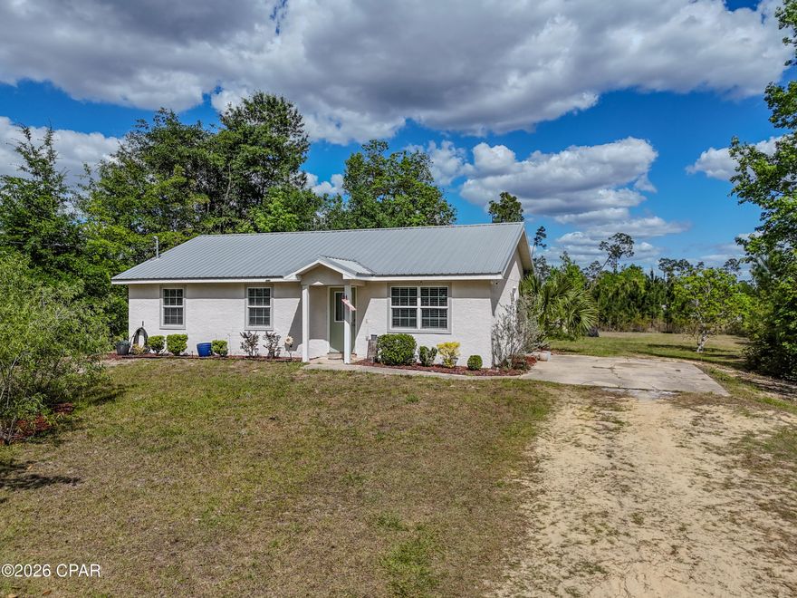 Conveniently located just off Highway 231 in Panama City, this property offers easy access to dining, shopping, and grocery stores, while still providing a peaceful setting just outside of town. Enjoy a short drive to Tyndall Air Force Base and the beautiful beaches of Panama City Beach, all while experiencing the tranquility of a quiet, no-HOA neighborhood. This spacious three-bedroom, two-bathroom home features an open-concept living and dining area designed for both comfort and functionality. The kitchen offers ample cabinet space along with stainless steel appliances, including a stove, microwave, and dishwasher. A conveniently located guest bathroom provides easy access for visitors and daily living. The well-appointed bedrooms offer plenty of space, highlighted by a large primary suite complete with a walk-in closet and private en-suite bathroom.
This well-maintained stucco home has been thoughtfully updated and features a freshly painted interior, including doors and trim, creating a clean, move-in-ready f, including insulation, drywall, ceilings, lighting, and flooring, countertops, and a durable metal roof in 2019, the well and septic system were replaced in 2022, and a new hot water heater was installed in April 2026, offering peace of mind for years to come.
Situated on nearly one acre, the property provides plenty of room to enjoy the outdoors and includes a playground and a utility building equipped with underground power and soundproof insulation, perfect for a workshop, hobby space, or additional storage. Seller is offering up to $7,500 toward buyer's closing costs with an acceptable offer, providing an excellent opportunity to reduce out-of-pocket expenses and make homeownership even more attainable.