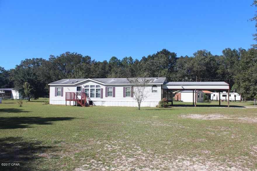 Very clean double wide mobile home built in 2006 located on a beautiful large one acre corner lot. This mobile offers a fully fenced-in yard with a large carport, screened-in back porch and two yard shed.  The interior of the home offers a split floor plan with a large living room and a very spacious kitchen with lots of cabinets and counter space.  The master bedroom has a large walk-in closet and the master bath has a double vanity, large tub and separate shower.  With the open floor plan, this home is perfect for families and entertaining.  The gorgeous lot offers shade and a pecan tree.  The home is just a short drive to Panama City Mall, restaurants and shopping.
