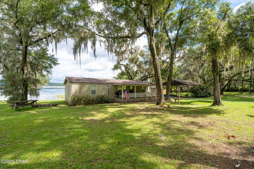OPEN HOUSE SUNDAY SEPT 14.  1:00 PM - 3:30 PM.  HICKS LAKE (POND) near Chipley, FL.  Are you craving a weekend escape from the hustle and bustle of city life?  Or maybe you're an avid angler in search of the perfect fishing spot?  Look no further!  Hicks Lake is a serene location that offers a peaceful retreat for nature lovers and outdoor enthusiasts.  The lake is 485 Sq Acres and is surrounded by lush greenery, providing a picturesque setting for activities such as fishing, swimming, birdwatching, boating, jet skis or simply enjoying the scenic views.  You can also engage in water sports like paddleboarding, kayaking, and paddle surfing, making Hicks Lake a perfect spot for outdoor adventures and relaxation.  The area is also known for its tranquil atmosphere, making it an ideal location for a quiet reflection or a rejuvenating outdoor experience. Only 45 minutes to Panama City Beach, FL and 15 minutes to Chipley, FL.  Remodeled 1989 24' x 72'manufactured home with 3/2 and 1,152 SF of living area with 2 large-covered porches.  Back porch is facing lake and is 12 x 30.  It's an awesome place to enjoy those panoramic lake views.    Outside has a 24 x 24 pole barn with separate storage building with outside sink and shower.  Also, has a deep submersible well ... additionally has a 30 amp RV power hookup.  For convenience seller's launch their boat from lakeside.  As a bonus you can go across street to boat launch and be in Lucas Lake.  Call today for private showing! MOTIVATED SELLER ... BRING REASONABLE OFFER!