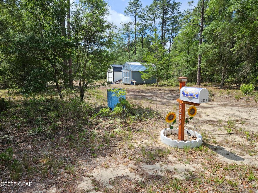 This flat lot has already been prepared for new construction. It has been cleared in the middle, has a deep well, septic tank and field lines, fenced on 3 sides, 2 new portable storage buildings each measuring 10x16, a circle driveway has been cut, and mailbox is up! It also has a numbered street address and is on the mailbox. A recent survey revealed the lot measures 1.27 acres. Now that Hwy 77 is mostly finished, it does not take long to get the Panama City from the security gated lake subdivision. It's about 30 minute drive to Panama City, and about a 40 minute drive to the World's Most Beautiful Beaches! Live gate guards are on duty weekdays, other times each property owner has a unique code for entry. The resort-like community offers 2 lakes, boat launch, swimming pool, covered pavilion with men's and women's restrooms, basketball court, tennis court, picnic areas, toddler playground and more. The fishing is good and a prime lake for exploring on a kayak or paddle board. Come see how life at the lake can be!