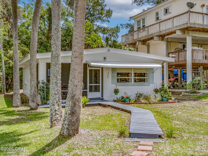 Bring your boat and swimsuit to this move in ready bay view cottage on Live Oak Island. This secluded gem has 2 bedrooms and 1 bathroom. Enjoy stunning views of Apalachee Bay and gorgeous sunsets from your living room or while relaxing on your screened in porch.  Come enjoy this tranquil bay view surrounding.  All the work has been done for you! Interior walls and floors have been recently painted.  Kitchen has all new stainless steel appliances and new cabinets.  Exterior has been painted, palm trees trimmed, and yard landscaped.  New ceiling fan on screened porch in 2024.  Chandelier installed in 2024.  Ceiling fan in living room new in 2023.  A/C unit new in 2022.  Tankless hot water heater new in 2021.  Washer and dryer stay. This inviting open concept cottage is perfect for your weekend getaway or vacation rental.  It is located right across from the private neighborhood boat launch.  Beautifully designed, super cute cottage!  Seller is a licensed real estate broker and is the listing agent. Lowball offers will not be considered!