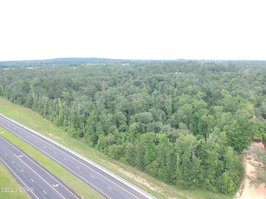 Unlimited Potential with this 25.15 Acre Parcel located less than 3 miles from Interstate 10.  This large land mass has been left to its original plush green Florida Landscape so YOU get to choose which trees you want to keep, where you want your driveway, and any other detail that might be important to you. This parcel has approx 1,300 feet of road front ON Highway 77 and 980 feet of road front on Houston Road. Whether you are thinking of Commercial Development or Residential Building this versatile 25.15 acres can fit the bill. Only a few minutes from Wal-mart Supercenter, Tractor Supply and fine dining. Drive a little further and enjoy The World's Most Beautiful Beaches Panama City Beach and Famous Pier Park Shopping along with Tyndall Air Force Base, Marianna Caverns several State Parks and North Florida's best kept secret, cool running deep water natural crystal clear springs. Just south about 40 miles there is Northwest Florida Beaches International Airport. The area around this parcel has some of the best fresh water fishing in Florida and Panama City Beach has some of the best salt water fishing on the planet. Parcels this size are getting harder to find in their natural state. Come and check out the hardwoods and pines, magnolias and dogwoods. Call today and lets make it happen.