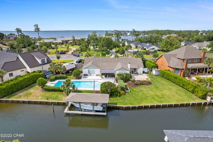 Tucked away at the end of the culdesac of highly sought after Robinson Bayou, this fully-renovated home offers 138' of well-protected waterfront with direct access to the Bay and open Gulf of Mexico. Featuring a 10,000 lb boatlift and boathouse and plenty of seawall for layalong, this is an ideal setup for your boating fleet. The backyard is truly an entertainers dream with an oversized pool and spa, covered and open patios, a carport for all the toys and lush landscaping all around. No detail was overlooked in this thoughtful open floor plan to include high, vaulted ceilings, shiplap accent walls, custom cabinetry and high-quality, modern Bosch appliances. Featuring four bedrooms, large home office, two bathrooms, spacious mudroom and a two-car garage, this is the perfect family home As you approach this one-level, modern brick home, you're greeted by a cozy front porch that exudes true southern charm. Enter into the foyer and you're welcomed with extra high ceilings, board and batten walls and a home office complete with custom built-ins and custom-designed sliding barn doors to ensure privacy while at work. Step into the vaulted dining room that is flooded with natural light, flanked with shiplap and features cozy views of the covered patio. Take a seat at the oversized kitchen peninsula where you'll stare at the shimmering shades of blues from your in-ground heated pool and the canal. You'll want to entertain every chance you get with this high performing kitchen displaying a 6-burner, dual-fuel gas range, pot filler, oversized microwave drawer, white apron sink, ultra-quiet dishwasher, custom pantry and a full-size coffee bar. The shiplap ceilings and Bosch appliance suite elevates the entire cooking experience! 

The custom-designed mudroom maximizes the space for utility and functionality and opens to the kitchen as well as the garage and open patio to the backyard. The family room is welcoming with vaulted ceilings, custom millwork built-ins and a wood burning fireplace to create the perfect living space. The master suite was truly designed to enhance serenity and relaxation. Oversized with vaulted ceilings, plenty of natural light flooding in, glass doors allowing for access to the patio and a master bath fit for royalty. This suite has incredible custom cabinetry with personal touches such as electrical outlets in drawers, pull-out full-size linen cabinets and a separate vanity most desirable for dressing. Thoughtfully-designed with shiplap ceilings, a full-size separate shower with natural light, a free-standing tub and custom-designed closets, this suite is a dream. Three additional bedrooms, a modern designed bathroom and luxury vinyl plank throughout round out this modern, transitional home. This home is on city water/sewer which is rare. Recently updated HVAC, hot water heater, roof and pool pump make it ideal for little to no maintenance required. Robinson Bayou is a quaint neighborhood centrally-located in Panama City. You do not want to miss this opportunity to live in a full-renovated home in the heart of town! Buyer to verify all dimensions and information.