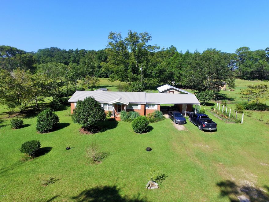 If you are looking for peace and quite this home is IT.  This home has 1943 sq ft under roof to include a two care carport and utility shed sits on 1.22 acres that is totally fenced and has a chain-link interior fence in the backyard. There are two septic tanks incase you have a RV to hook up. Home is all brick with new 30 year metal roof, new laminate flooring, new interior paint, double pane windows and kitchen backsplash. There are new motion sensor lights all around outside of home and backside of workshop. Very nice 24 x 18 workshop with a 24 x 9 lean-to.  Outdoors includes a small gardening area, producing pecan trees, blueberries, thornless blackberries, plum trees, satsuma oranges and bronze and purple muscidines. OWNERS ARE VERY EAGER TO SELL THIS HOME!