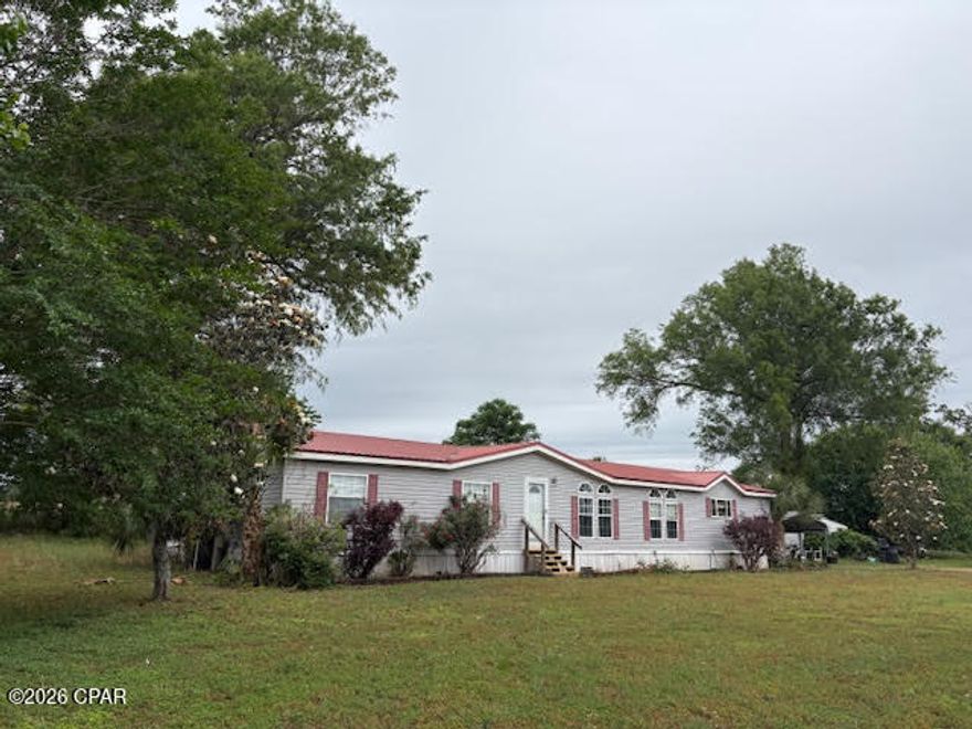 Discover the possibilities with this 10.33-acre property offering space, flexibility, and a prime location along a major four-lane highway with convenient access north toward Montgomery and south to the Gulf Coast beaches.  The property features a well-maintained 4-bedroom, 2-bath doublewide mobile home with 2x6 exterior walls and a desirable split-bedroom floor plan. Inside, you'll find a spacious kitchen and dining area with abundant cabinet and counter space, plus a cozy wood-burning fireplace in the living area. The large primary suite includes a walk-in closet, jetted tub, separate shower, and double vanity. Two additional bedrooms also offer generous walk-in closets.  Outdoors, enjoy established fruit trees--including peach, pear, chestnut, mulberry, and apricot--supported by dedicated water lines. Additional improvements include a storage building and a metal carport that can also serve as a covered outdoor entertaining space.  A 2006 3-bedroom, 2-bath singlewide mobile home is also on the property and may remain with acceptable terms or be removed prior to closing.  For those seeking even more space, an adjoining 10-acre parcel with a brick home and large barn with stalls is available for purchase (see MLS 789294). This property presents an excellent opportunity for a family compound, hobby farm, or investment.