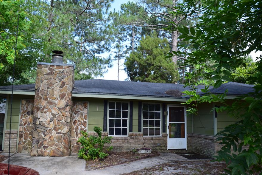 This home is located in a quiet family neighborhood in Lynn Haven and is close to the super Wal-Mart. This house has great potential. In addition to the large living room, there are two bonus rooms. A large stone fireplace graces a living room wall. The backyard is fenced and has two yard buildings. The beautiful yard is shaded by several large trees.