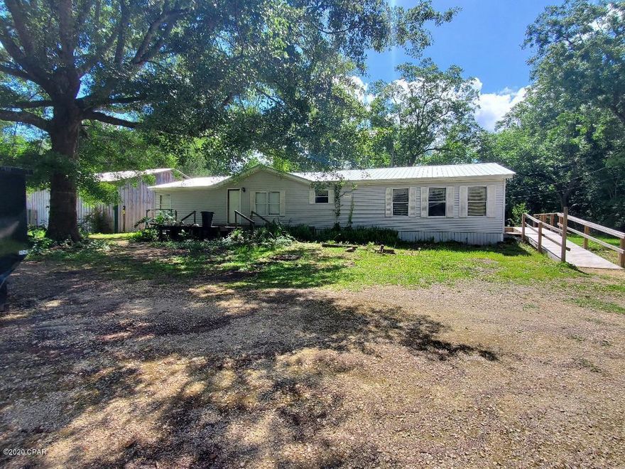 This 1782 sqft 3/2 DWMH is setting on 1.37 ac in city limits. This home features new metal roof, vinyl and laminate flooring, glass sliding door in large living room, nice size master bedroom and bathroom, nice utility room, large kitchen and dining, per owner A/C is 3 years old and a 36x30 work shop. MAKE YOUR APPOINTMENT TODAY!!