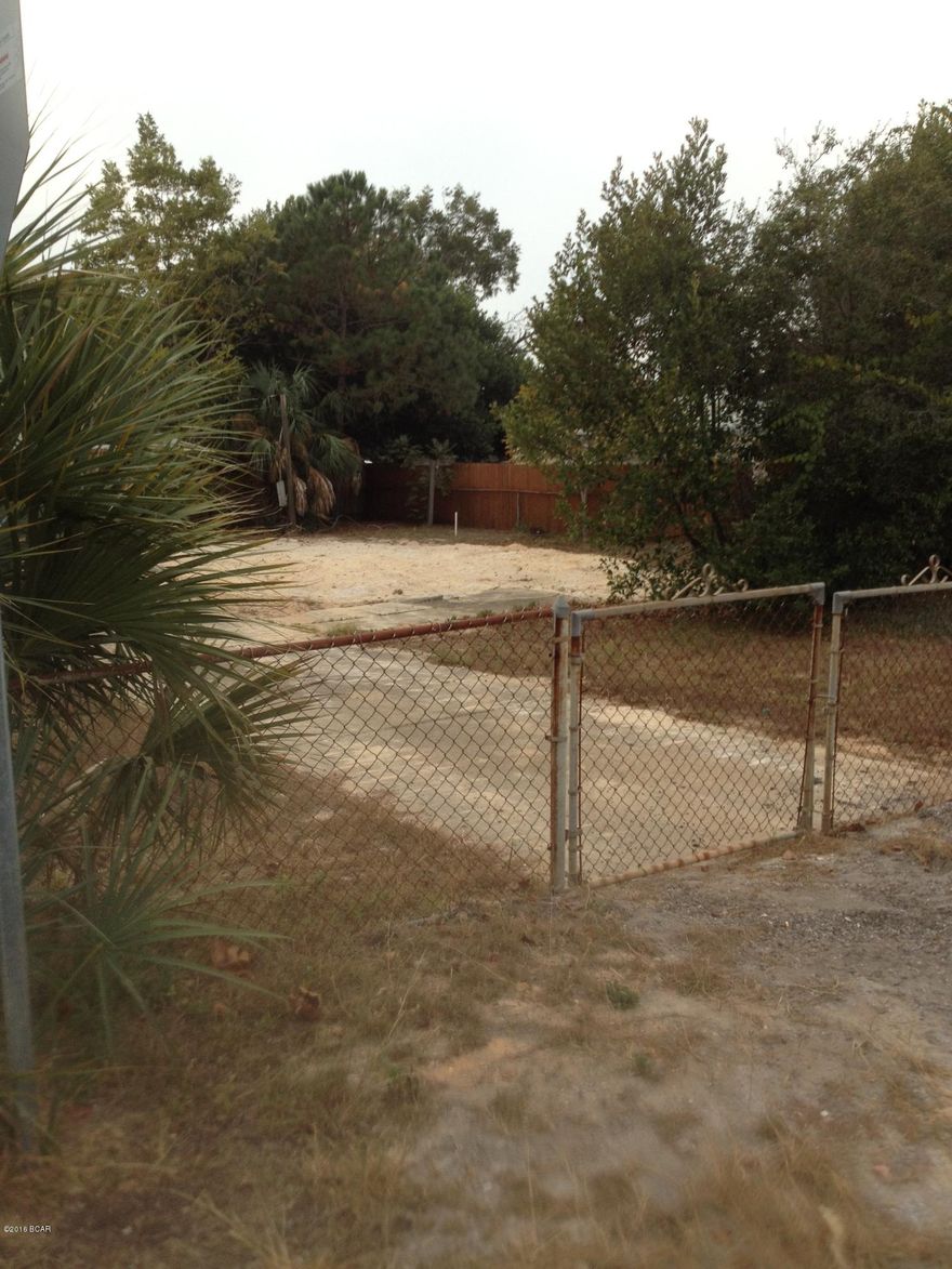 DOUBLE CORNER Lot in Laguna Beach on the very popular and sought after ''West End'' of Panama City 

Beach. This lot is fully fenced and has a beautiful Pecan tree, Palm tree, and an existing driveway and a few other shrubs - cleared and ready for you to build on! 100'x65'. Power and water are run to the lot. Old septic has been removed and lot is grandfathered into new regulations for septic permit as long as no boundary lines are re-drawn. All land measurements, proximity to gulf, and connection of any utilities are the responsibility of the buyer so please make appropriate inquiries. Please do not walk property without the representation of a REALTOR for your safety.  There is loose sand, and some left over utility equipment on the property.