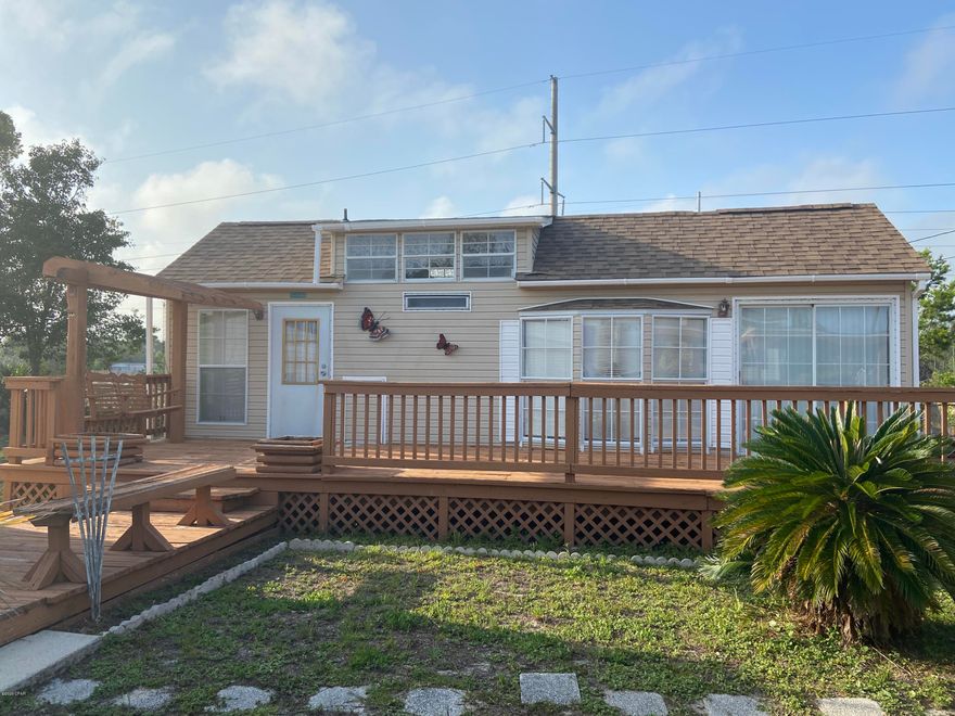 CURRENTLY UNDER CONTRACT, SELLER ACCEPTING BACKUP OFFERS-This is a one of a kind Beach ''Barbie House''.  Only has had one owner and although  it needs a little TLC you can still see it was well cared for. A short 5 minute drive to the beach. This home offers a 1 bedroom, 1 bath, carpeted loft area perfect for sleeping area for children or additional storage.  Vaulted ceiling in the living room and abundance of windows that provide natural lighting. Carport has fan and electricity and would be a great covered area for gathering with family and friends. Make sure you look in the shed and you will be surprised to find a one room bunk house and additional bathroom with a garden tub. This is your OPPORTUNITY to have your own ''tiny house'' on a large lot for only $98,000. Verify measurements if important to buyer.