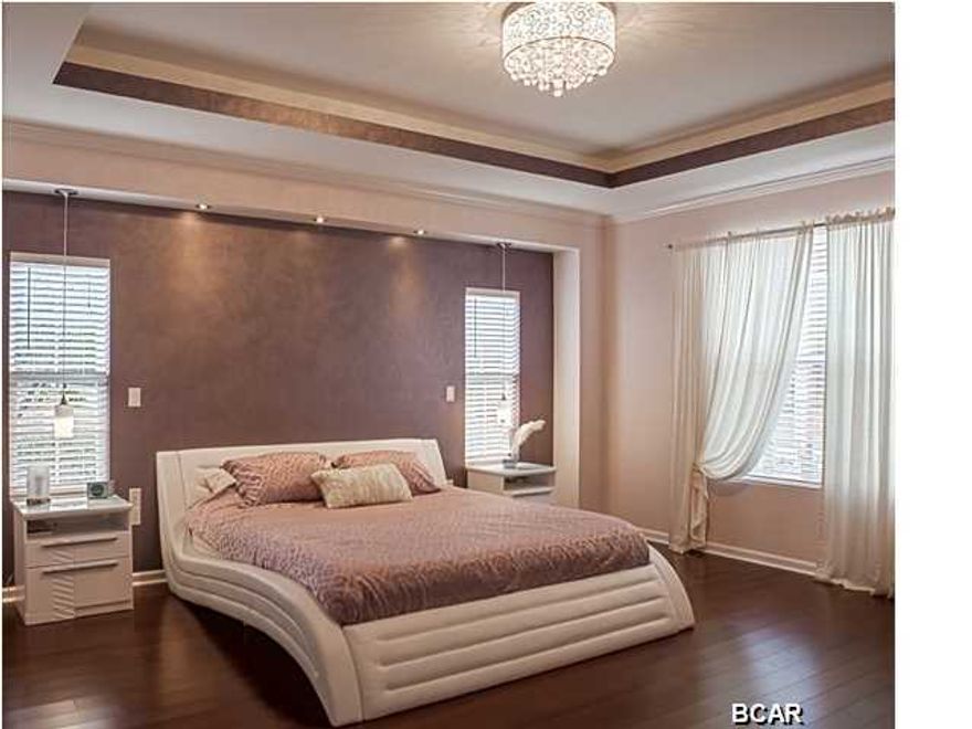 Truly unique, sophisticated, modern newly built home is located in a well established neighborhood of Lynn Haven. This spacious 3171 square ft. 4 bed. 3 bath 3 car garage (1 car garage/ workshop) is featuring an open floor plan, boasts 11 ft. tray ceilings, recessed lighting, motion lighting, crown molding, niches throughout, built in modern entertainment center featuring built in wine cooler/ bar. Well equipped kitchen features stainless energy efficient appliances including an induction stove top, solid wood cabinets, quartz countertops, breakfast bar with pendant lights and huge pantry, stunning wood and ceramic flooring, Heated Flooring in Kitchen and Master Suite. Crown molding adorns the main areas such as entrance, great room, kitchen and master bedroom. Master bedroom features