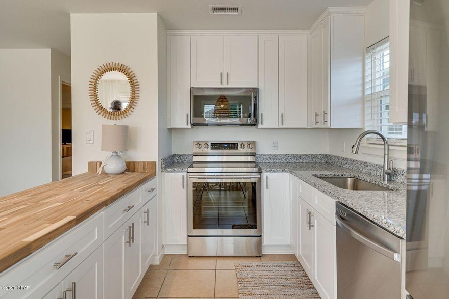 CURRENTLY UNDER CONTRACT, SELLER ACCEPTING BACKUP OFFERS. Newly renovated beach home with Gulf views on the west end of Panama City Beach, just one block from the beach! Situated on a spacious corner lot shaded by mature oak trees, this hidden gem just finished a complete remodel with all new flooring, windows, doors, cabinetry, interior and exterior paint, stainless-steel appliances, and more. The first floor boasts a 1-bed, 1-bath spacious open floor plan with reinforced concrete block construction and a spacious laundry room. Upstairs, the 2nd floor with private entrance features 2 bedrooms, a full bath, 2-in-1 washer/dryer and a spacious balcony with Gulf views. Sells fully furnished and turn-key ready for immediate rental or personal use!