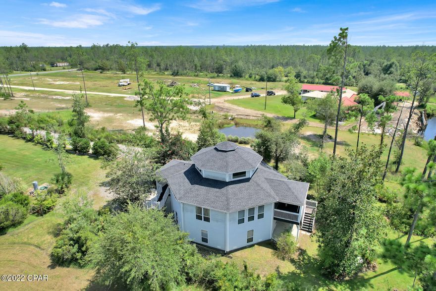 Bring your boat to your own tropical paradise. After winding down the long driveway, you will be welcomed by an amazing 3 story home, perched on the banks of the Wetappo Creek. This fully furnished home sits on nearly 2 acres with 120+ feet of water-front, including a large dock, covered wet slip, and dock house. Jump in the boat and head out to the gulf for fishing, beaches, boating, and relaxing. The lower level includes a 4-car garage, workshop, and extra storage room. 3 staircases lead to the second level which boasts 2-bedrooms, 2-bathrooms, laundry room, utility room, along with a spectacular living room with soaring cathedral ceilings, and gas fireplace. The second level also includes a large kitchen that has white custom-built cabinets, granite countertops, stacked stone backsplash and GE slate smudge-free appliances. The over-size laundry room includes Kenmore Elite washer/dryer with a laundry tub and plenty of room for storage. The huge loft can be used as a third bedroom with amazing panoramic views of the property. The large screened in back porch is the perfect spot to sit back and relax while enjoying the breathtaking views of the water. This home has Bay/Gulf from Wetappo Creek. All measurements are appox. Please verify if important.