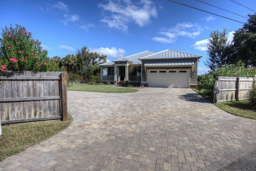 Live the dream life in this absolutely beautiful, practically new ''to die for'' home on Grand Lagoon with a boat house, lift and easy gulf access!  Just built in 2014 & the owner spared no expense. With it's coastal cottage flair, 10 ft. ceilings, hard pine floors, huge porches and lots of windows to enjoy the gorgeous view of the water you will never want to leave.   The living/dining/kitchen areas are all open making it an entertainers delight. The floor plan is split with the Master bedroom & a guest room overlooking the water. Guys will love the humongous 24x30 garage and  spacious yard which is 2.5 lots.  The construction is top notch with 2 rolls of Sharkskin under the Aluminum roof, sprayed foam insulation from top to bottom, and the finest materials throughout.  The home has a vid video security system, surround sound throughout, and luscious landscaping outside.  It is less than 1/2 mile to the beach so an easy walk, golf cart ride over to Schooners!  All this and with a full price offer the seller will include the furnishings!  This is a delight to see so be sure to schedule a private tour.