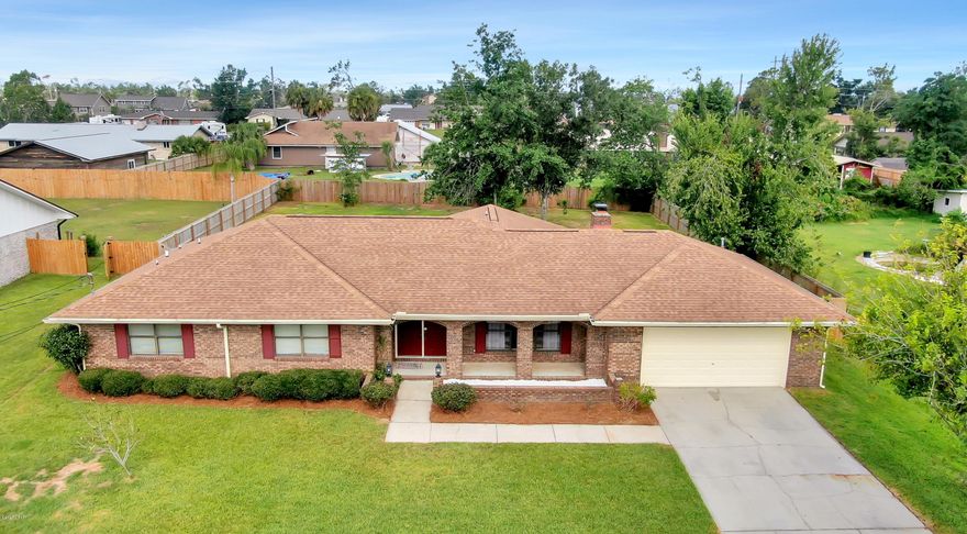 Solid Brick Home – Pool – Backyard Oasis – Lots of Space!  What else could you ask for?  This 4-bedroom home offers comfortable living space for a family, guests, or hobby rooms. The large living room is bright and airy with its oversized picture windows and vaulted ceilings and the wood burning fireplace will give a warm ambiance on those chilly days.  The kitchen has upgraded cabinets with pull out shelves, granite counter tops, stainless appliances and a breakfast bar for your morning cereal or cup of joe.  The separate dining room, with its pretty French doors leading to the patio, is a great space for holiday meals, or it could even be utilized for an office space. The master suite is large enough for a King-sized bed and has two closets for all those clothes, one being a walk in! The vanity is outside the en suite bath making it convenient for a couple's busy morning. The 3 guest rooms are good sized and give plenty of room to stretch out and the guest bath has a double vanity.  The sizeable laundry room easily shares its space as a mud room. It has a utility sink and extra closets and shelving for additional storage or pantry space!  The back yard will be your private little get away. The sparkling in-ground pool, new privacy fence, mature trees that were saved from the storm, and over-sized lot is perfect for the kids or fur babies to play.  Enjoy BBQing or build a fire pit for those social gatherings. The outside shower is plumbed for hot water making it comfortable to hose off. Too hot or just want to enjoy the smell of a rainy day? Relax in the large screened-in patio just off the kitchen or enjoy the covered front porch.  The owners have taken great care of this home and a few bonus features are the new Ultra-Quiet garage door opener, Smart Ring doorbell, new pool pump and a french drain installed in the backyard to prevent water build up! This home is in an excellent centralized location - just a few blocks from shopping and only 20 minutes to Tyndall AFB and our emerald beaches!  Seller is offering a one-year home warranty for the buyers' piece of mind.  All measurements approximate, buyer to verify if important.
