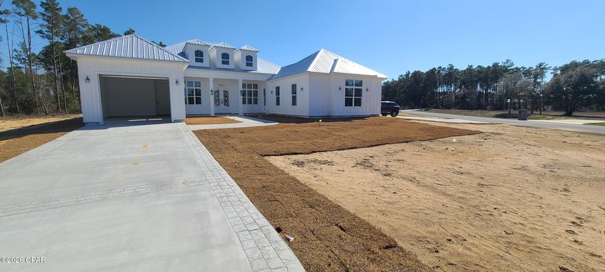 Welcome to the spectacular sandhills of North Bay county! Come visit this exquisite 3 bedroom 3 1/2 bath home located on a large 1.14 acre corner parcel across from the pristine spring-fed Bream Pond. The whole community has underground electricity and paved roads.  This masterful custom home is currently under construction and estimated to be completed around the end of this month. Recently installed is the captivating oversized French front door made from rod iron with an exceptional filagree design. The spacious great room has a expansive tray ceiling combined with the dining area and boasts an open floor plan. The back wall of this room has 8 x 16 ft. sliding glass doors that open to a large outdoor covered lanai that is ready for an outdoor kitchen and fireplace. It has a split bedroom plan with the master located on the east side of the home. This luxurious master bedroom has a tray ceiling and features an ensuite bathroom that includes 2 separate large walk-in closets, a striking walk-in tiled shower, his & her sinks separated by a middle vanity that are combined with tall end cabinets that are all custom designed with the same white solid wood cabinets used throughout the home. The back closet comes with a private pocket door that conveniently opens into the laundry room. Each of the additional bedrooms has their own ensuite full bathroom. The well-planned kitchen encompasses a breakfast bar island all stainless appliances, under-cabinet lighting, a gas cooktop with an industrial style hood vent, built-in stacked microwave and oven, dishwasher, french door refrigerator, and a generous walk-in pantry. Finishes include 8 ft. arched doorways, luxury vinyl plank flooring & white wooden cabinets with beautiful quartz counter tops. Outside is an in-ground gas tank that is plumbed to the lanai, kitchen and tankless gas water heater. Overall this home boasts a total of 4144 sq. ft. under roof. There are 2 attached garages- a double and a single to allow for 3 vehicles. It also includes a extra outdoor accessible storage room located at the rear of the home. This executive home is only 3 traffic lights (18 miles) away from the North Florida Beaches international airport with it's growing industrial park and new Hilton hotel. Bring your best offer and begin the new year with peaceful country living at it's finest!  Motivated seller! More detailed photos will be provided through out the finishing of construction. Listing agent is related to the builder.